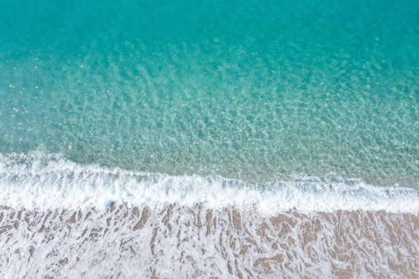 海滩上蓝色的大海和白色的海浪的俯视图。库存图片图片下载