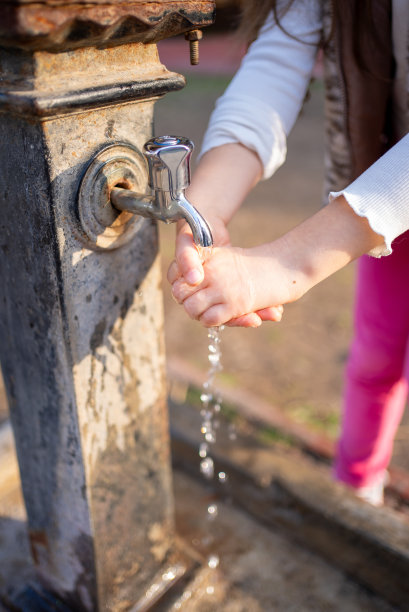这个小女孩正在公园洗手。库存图片图片下载