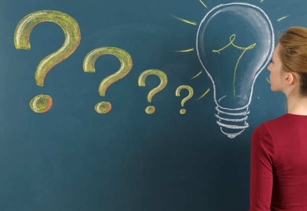 黑板上有问号和电灯泡的年轻女子图片下载