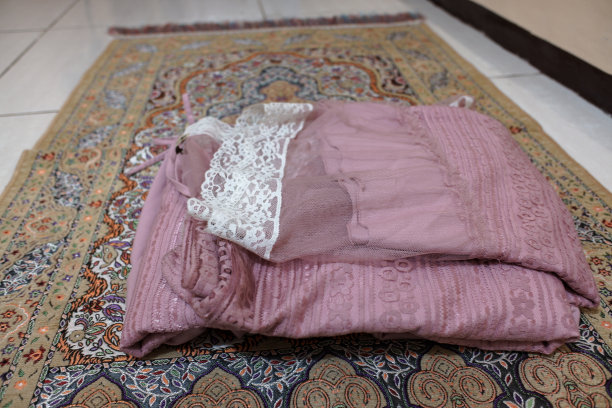 一件粉红色的头巾叠在祈祷垫上图片下载