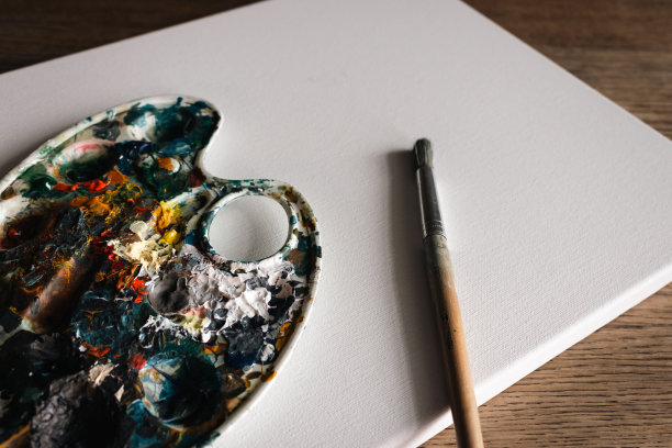 调色板与明亮的颜色与油漆刷在白色的背景。抽象艺术。使用复制空间绘制调色板。画画的爱好。各种颜色的混合。创意设计。灵感的想法。图片下载