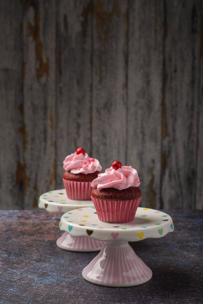 纸杯蛋糕在小陶瓷板与木制底部与复制空间。产品照片。图片下载