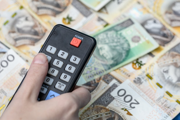 打开电视遥控器上的一频道，背景是现金和波兰货币图片下载