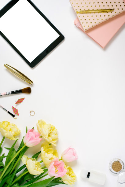 春天的平面游戏，键盘，笔记本，化妆品，平板化妆和一束粉红色和黄色的郁金香在浅色背景与复制空间。一个博客的春季概念。情人节或母亲节的贺卡图片下载