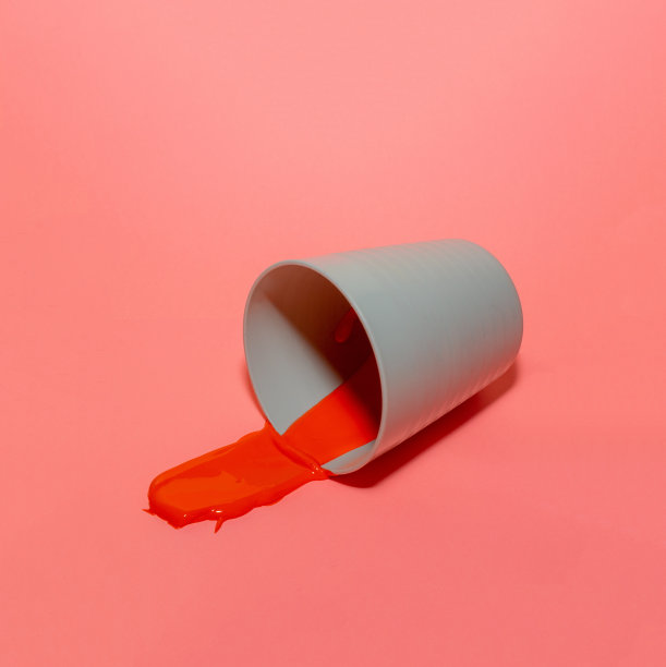 红色的油漆从杯子里洒了出来图片下载