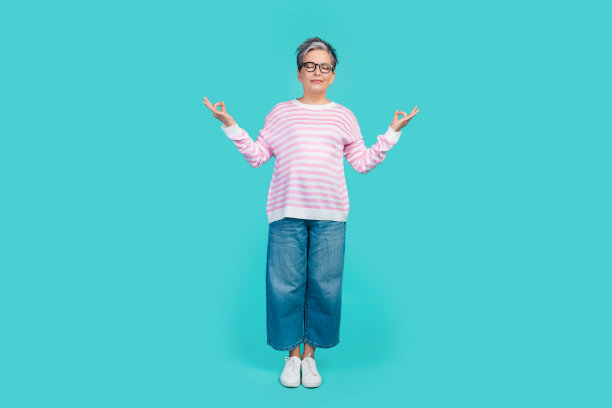 可爱的梦幻女人穿着粉红色的套头毛衣眼镜练习瑜伽闭上眼睛孤立的蓝绿色背景的全长照片图片下载