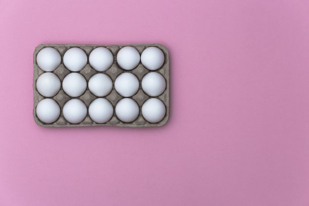 白色的鸡蛋在盒子上的特写粉红色的背景-股票照片图片下载
