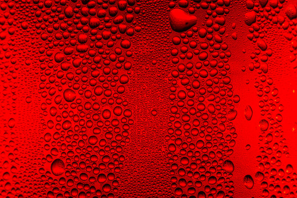 特写红色微距饮料水滴表面，水滴在一杯红色冷饮上为背景和质感。(特写，选择性聚焦，留出文字空间)图片下载