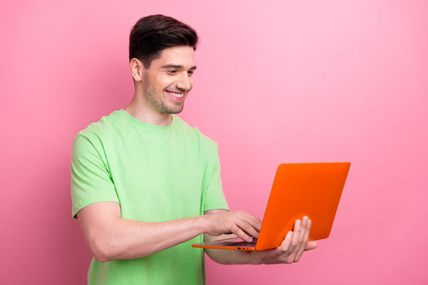 年轻人的照片程序员网页设计师使用上网本创建方便的界面，网站隔离在粉红色的背景图片下载