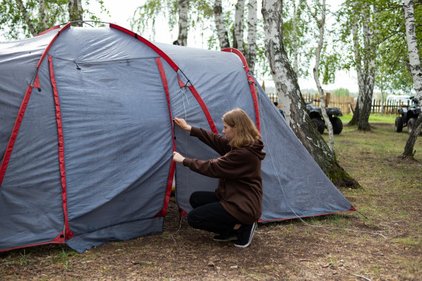 一位妇女在森林里搭起了帐篷。旅程。图片下载