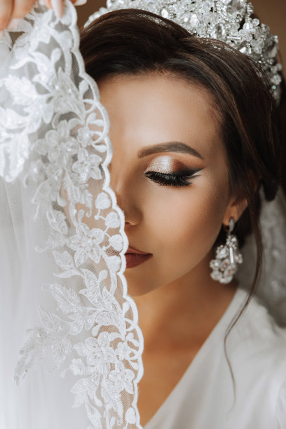 一位美丽的黑发新娘，头上戴着头饰，穿着漂亮的睡袍，准备参加婚礼。特写婚纱照，照片。图片下载