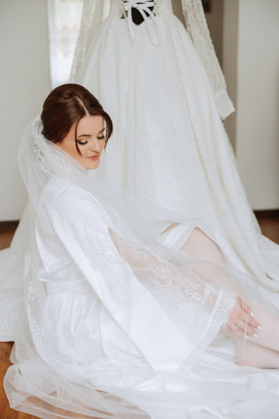 一位美丽的黑发新娘，头上戴着头饰，穿着漂亮的睡袍，准备参加婚礼。特写婚纱照，照片。图片下载