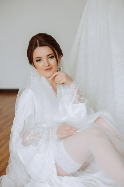 一位美丽的黑发新娘，头上戴着头饰，穿着漂亮的睡袍，准备参加婚礼。特写婚纱照，照片。图片下载