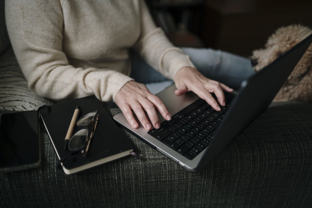 女人的手在笔记本电脑上打字图片下载