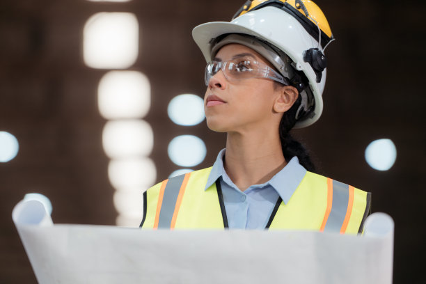 穿着安全背心和安全帽的铁路技术工人在火车维修站按图纸工作的照片图片下载