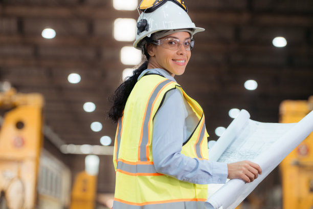 穿着安全背心和安全帽的铁路技术工人在火车维修站按图纸工作的照片图片下载