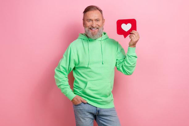 照片时髦开朗的家伙穿着绿色卫衣上升心像通知卡孤立的粉红色背景图片下载