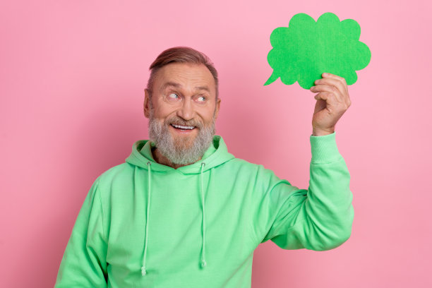 照片的兴奋梦幻的家伙穿着绿色卫衣显示思想泡泡空空间孤立的粉红色背景图片下载