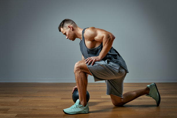 强壮的男人用健身球做运动。灰色背景上完美体格的男子照片。力量和动力。图片下载