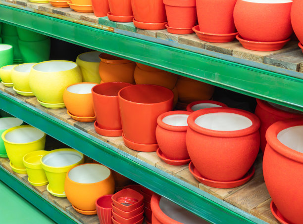 商店或温室里的空花盆。商店里的陶瓷或塑料花盆。商店货架上五颜六色的花盆。图片下载