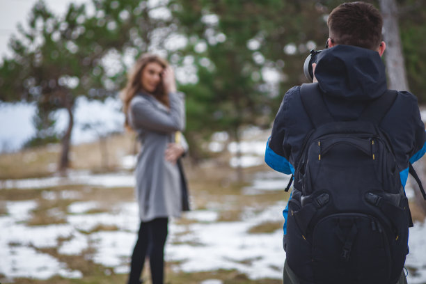 摄影会议-年轻的摄影师在冬天拍摄关于大自然中的美丽女人的照片图片下载