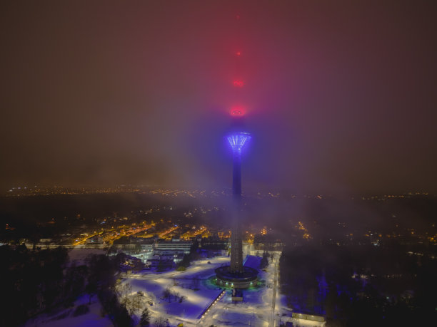 塔林电视塔在夜晚的雾中发光，这是一架无人机在微光下拍摄的照片。图片下载