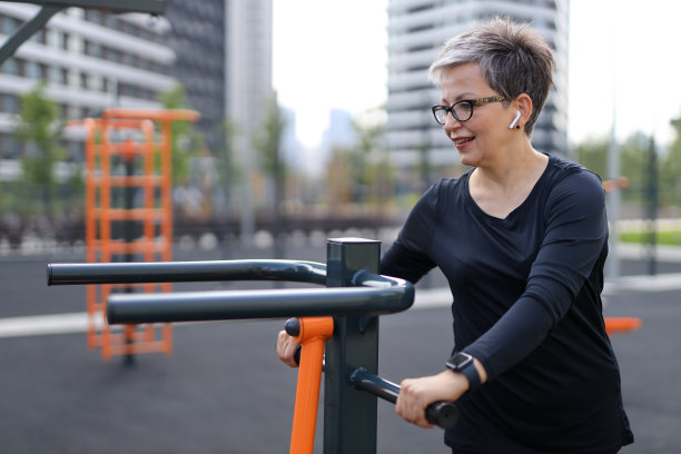 成熟坚强的女人，一个健身模特，在户外锻炼时微笑，散发着幸福和健康。图片下载