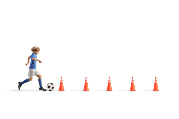 一个男孩带着足球在障碍物之间奔跑的全长侧面照片图片下载