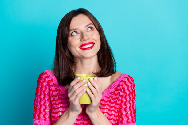 照片正面的女孩觉得有兴趣喝咖啡休息喝热饮孤立的蓝色背景图片下载