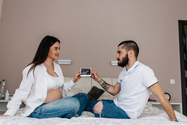 美丽孕妇和英俊丈夫拿着超声波照片的局部照片图片下载