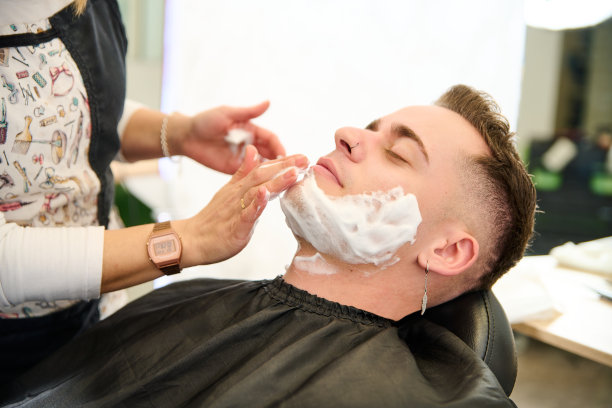 理发师在理发店用直刃剃刀刮胡子的年轻人图片下载