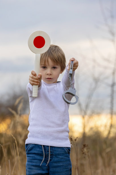 小孩，男孩，手持起/停警察控制交通桨图片下载