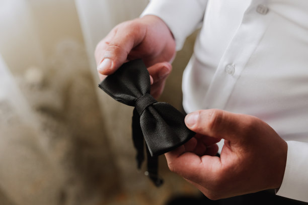 男人手里拿着领带，手的特写照片。新郎正在为婚礼做准备。最后的准备工作。图片下载