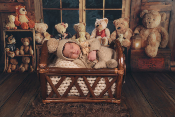 一个新生婴儿和泰迪熊一起睡在篮子里图片下载