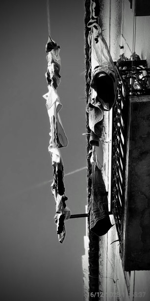 黑白照片，衣服挂在建筑物的一侧图片下载