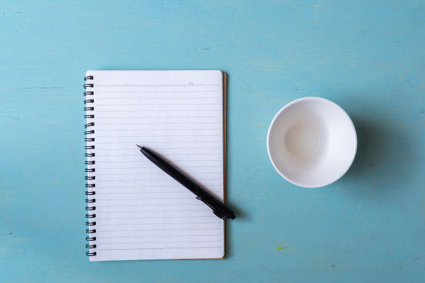 普通的笔记本和白色的杯子图片下载