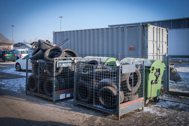 在一家汽车修理店的院子里，装满旧轮胎和汽车零件的集装箱图片下载