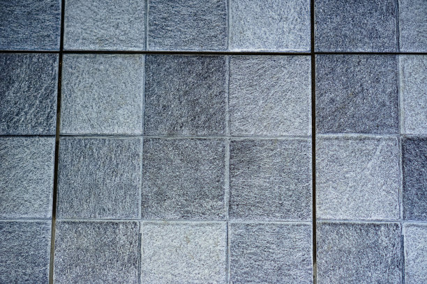 公共厕所里灰黑色瓷砖地板的特写背景图片。图片下载