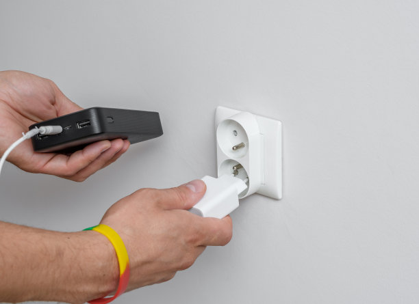 充电宝连接在墙上的充电器插座上图片下载