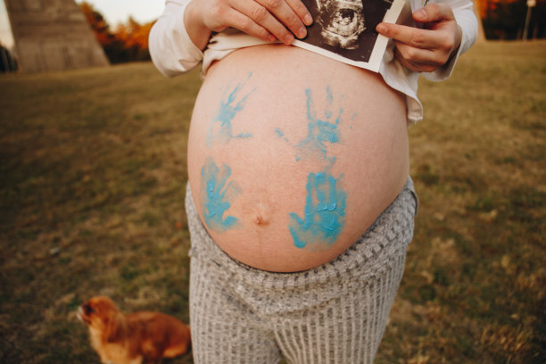 孕妇的腹部与蓝色油漆库存照片图片下载
