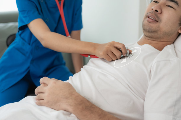 医生用听诊器听躺在病床上的病人的心率。医学概念。健康检查。亚洲模式。女性心脏病专家检查男性患者的保健观念图片下载