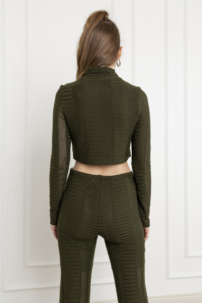 金发碧眼的年轻女子穿着高领毛衣和长裤套装。图片下载