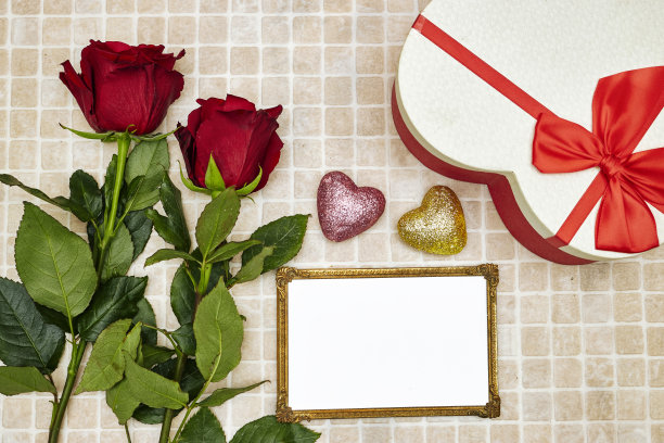 金色的照片或相框模型与玫瑰鲜花和礼物心形盒子情人节图片下载