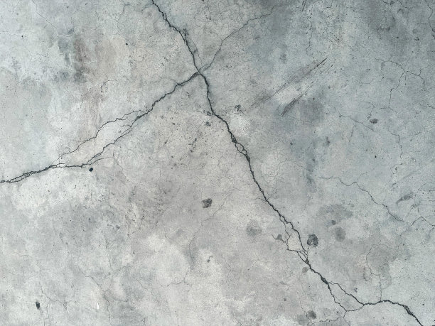 一个人在水泥地面上滑滑板的照片。图片下载