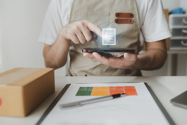 智能手机被用来进行各种促销活动，在线商店的老板根据在线销售网站的订单将产品包装成包裹盒。图片下载