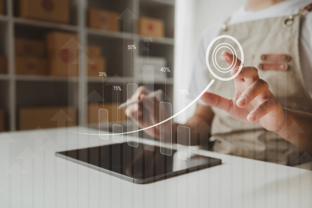 平板电脑被用来做各种各样的活动来促进商店的销售，网上商店的老板根据在线销售网站的订单将产品包装成包裹盒。图片下载