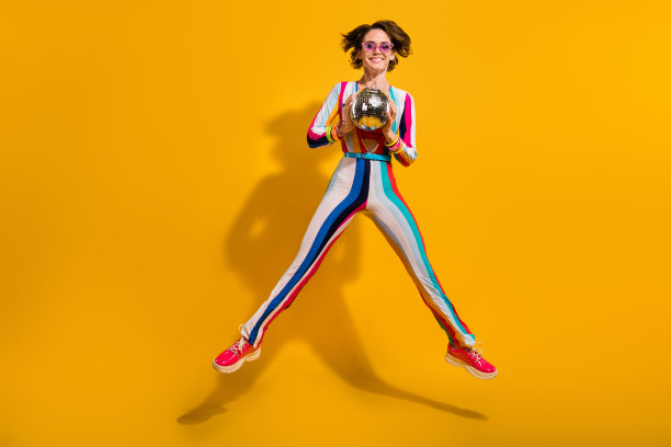 年轻的女孩俱乐部跳持有迪斯科球孤立亮色背景的照片图片下载