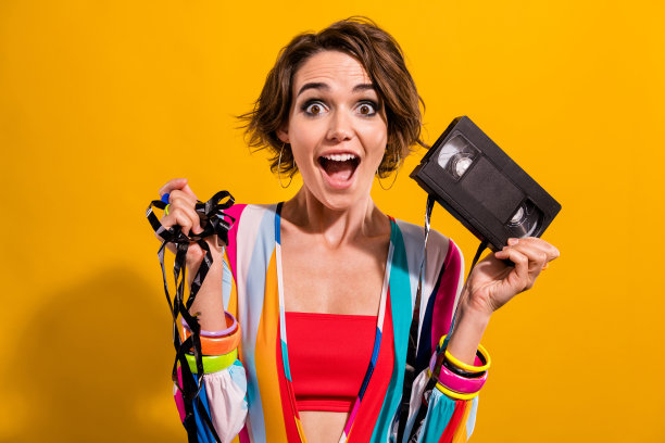 照片的疯狂惊讶的女孩拿着磁带记录为家庭电影周末聚会孤立明亮的色彩背景图片下载