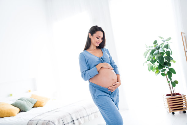 开朗可爱温柔的怀孕女孩摸着大肚子等待第一个新生儿出生的照片白色灯光室内室内图片下载