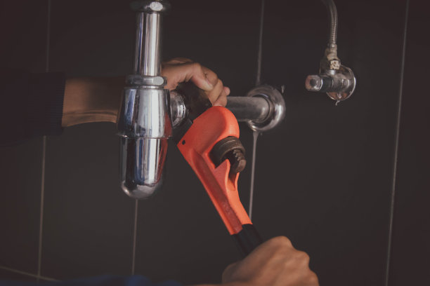 在浴室工作的水管工，管道维修服务，修理水管道泄漏，更换厨房水槽排水管图片下载